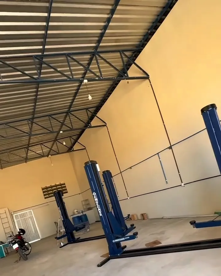 Galpão da oficina com elevadores automotivos azuis instalados